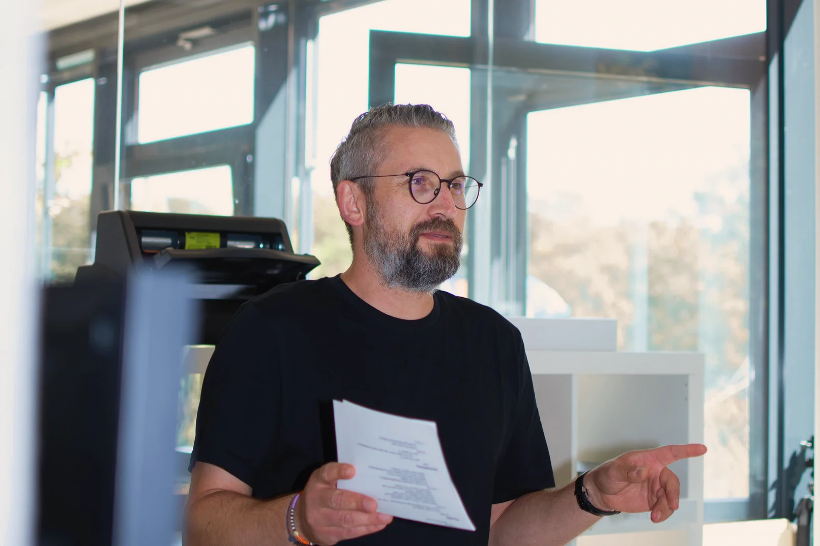 Mann mit Notizzettel in der Hand der einen Vortrag hält