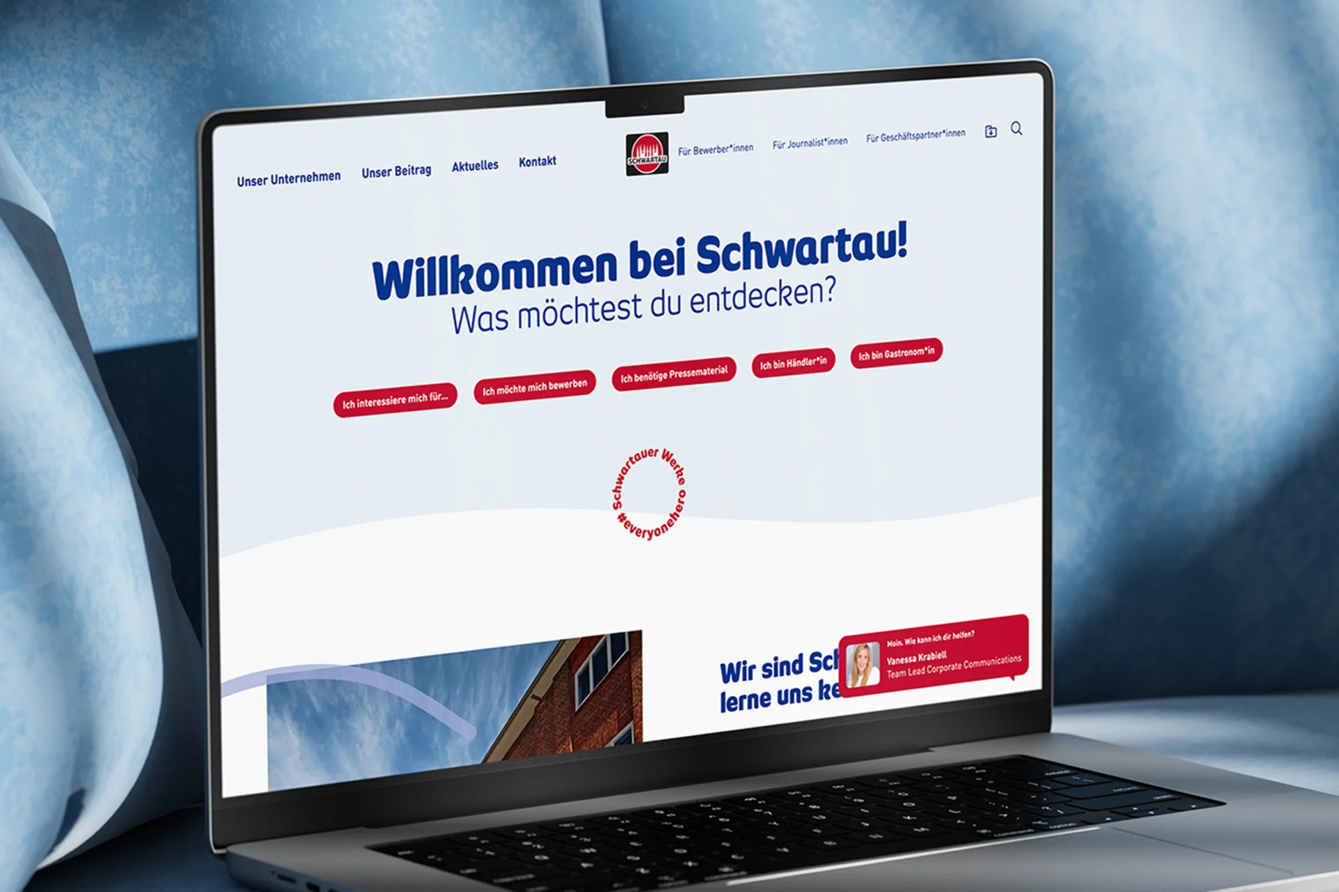 Aufgeklappter Laptop, stehend auf blauem Polster mit geöffneter Website der Schwartauer Werke