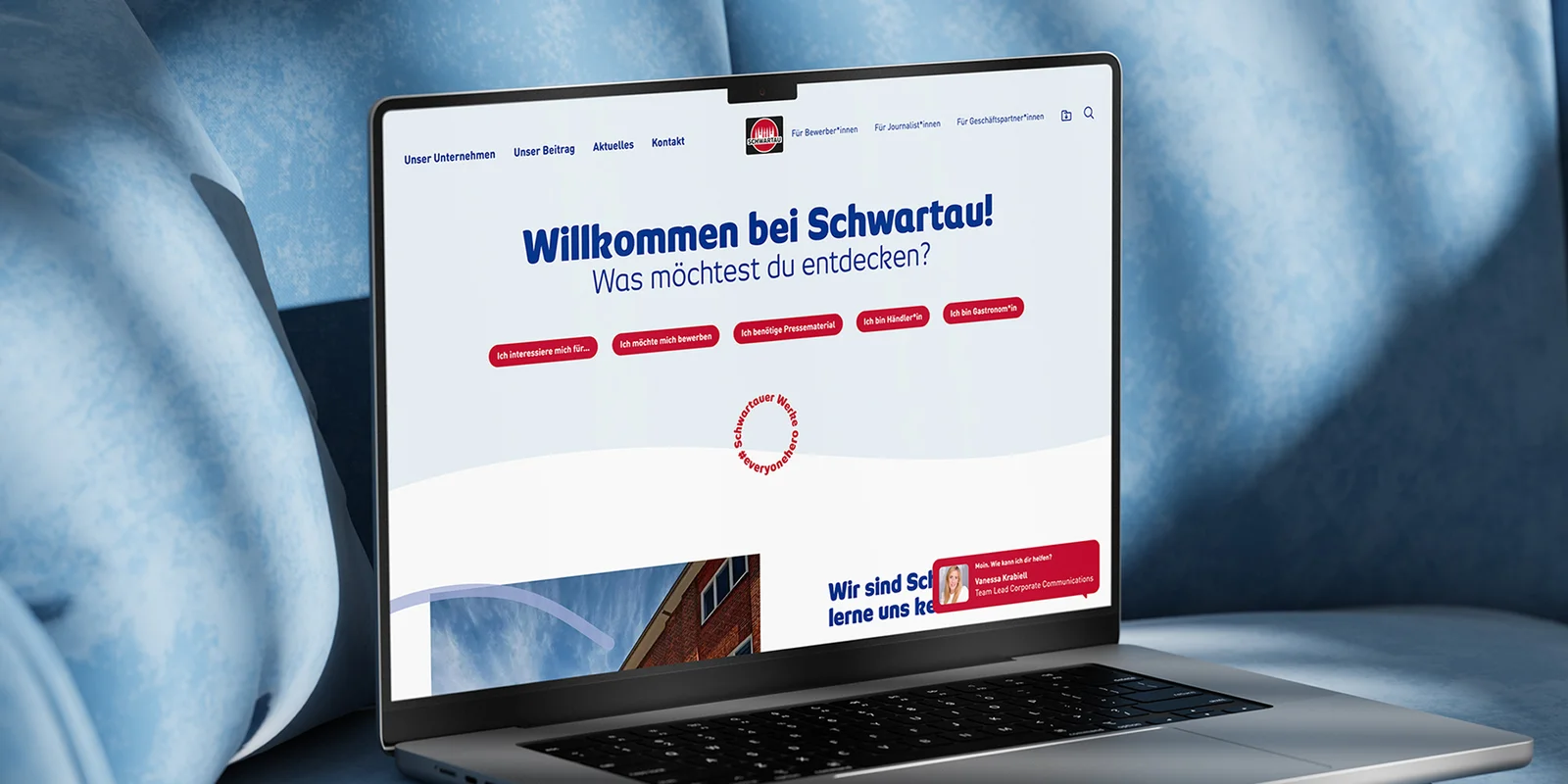 Aufgeklappter Laptop, stehend auf blauem Polster mit geöffneter Website der Schwartauer Werke
